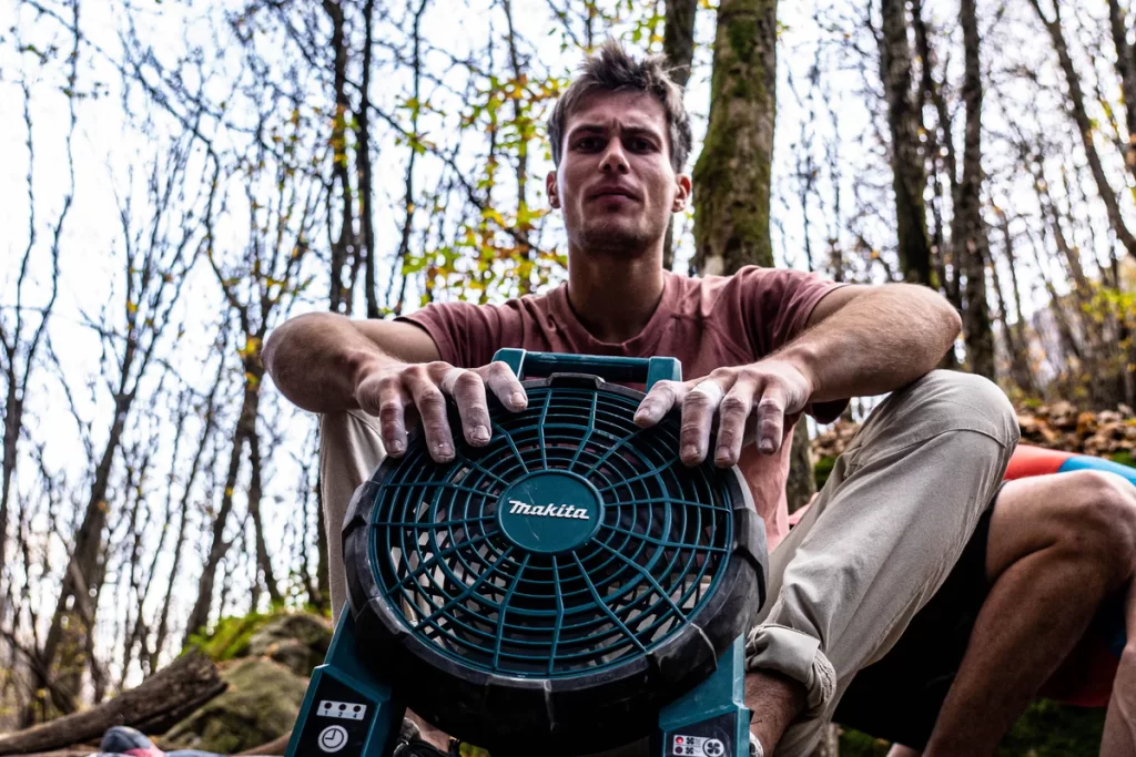 photo of a climber with hands in front of a fan. 